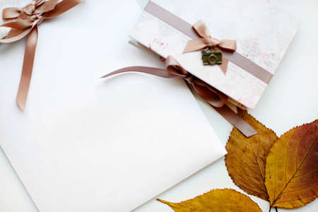 Autumn gift in craft paper and dry leaves with free copyspaceの写真素材