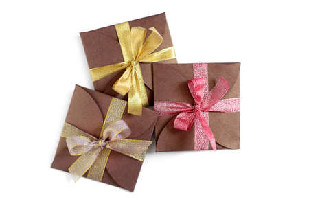 Christmas gifts wrapped in brown paper with the bow top view isolated on white backgroundの写真素材