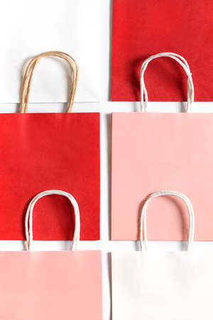 Red, pink and white shopping bags from recycle paper isolated on white background. Packets for gift or present.の写真素材