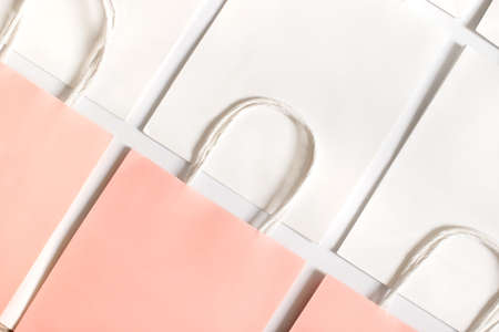 One pink shopping bag in background of white bags isolated on white background. Black friday or Christmas sales.の写真素材