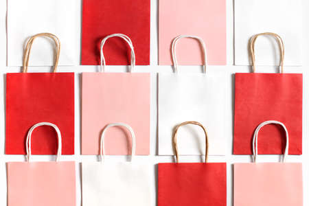 Red, pink and white shopping bags from recycle paper isolated on white background. Packets for gift or present.の写真素材