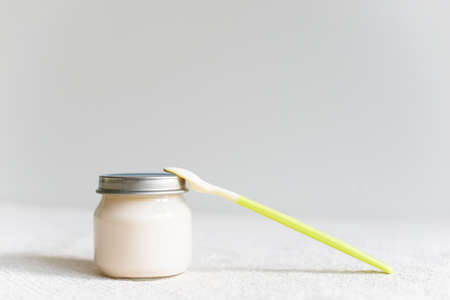 Bowls of pureed food with spoon for baby over blurred background with free copy spaceの写真素材
