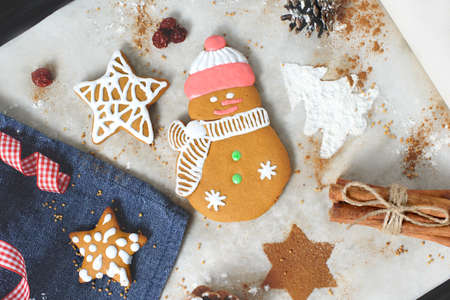 Christmas cookies in shape of stars and snowman with festive decoration on paper and towel background.の写真素材