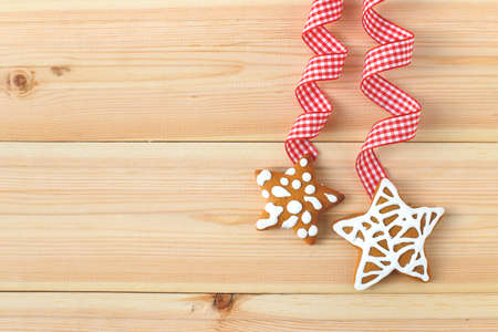 Christmas cookies in shape of stars with festive decoration on wooden background. Free copy space.の写真素材