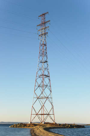 Pylon and transmission power line on the sea coast in front of sky.の写真素材