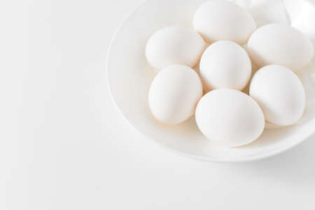 White eggs on a plate on a white background. Easter photo concept. Copy space. View from above.の写真素材