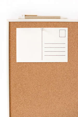 White postcard with free copy space pinned on cork board on a wall. Office or school concept.の写真素材
