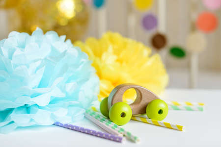 Various festive paper decor and balloons and wooden car toy in front of baby bed. Baby bedroom interior. Baby birthday celebration concept.の写真素材