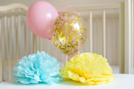 Various festive paper decor and balloons in front of baby bed. Baby bedroom interior. Baby birthday celebration concept.の写真素材