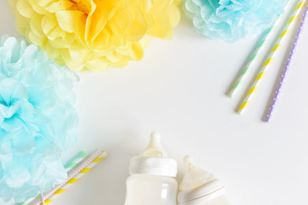 Baby bottle with breast milk, various festive paper decor. It's a boy or baby birthday celebration...