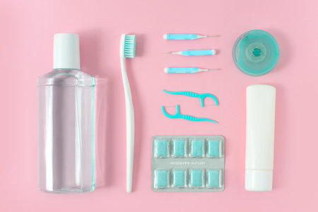 Toothbrushes, toothpaste, rinse and chewing gum set on pink background. Dental and healthcare concept. Free copy space.の写真素材