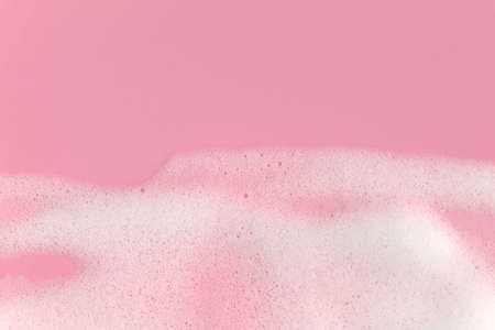 Soap foam bubbles on pink background macro close up. Free copy space.の写真素材
