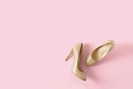 Beige women high heel shoes on pink background.の写真素材
