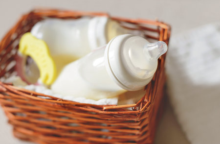 Two bottles with breast milk for baby in a straw basket. Free copy space.