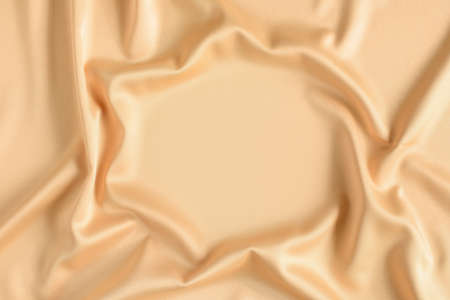 Close up of ripples in gold colored silk fabric in shape of frame. Satin textile background. Free copy space.の写真素材