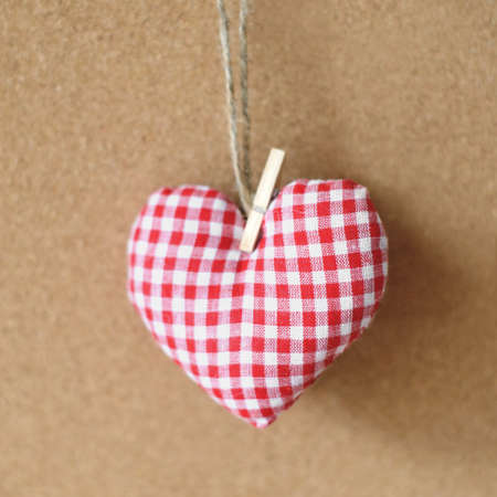 Red textile heart over brown craft recycle cork board background. Valentine's day concept.の写真素材