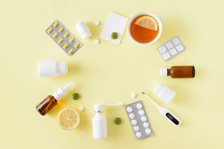 Cold and flu treatment set. Pills, throat spray, medical mask, thermometer, recipe on simple yellow...