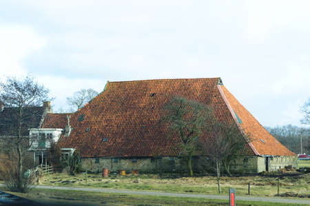 Old traditional village house with tiled roof in Netherlands.の写真素材