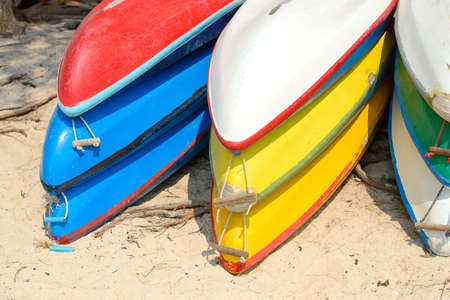Kayaks stacked on sand beach. Colorful boats in front of sea coast. Vacation and travel sport activity. Free copy space.の写真素材