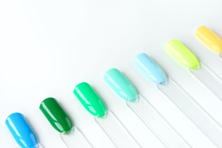 Nail polish samples in different bright colors. Colorful nail lacquer manicure swatches. Top view of...