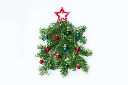 Stylized Christmas clock made of fir-tree branch and red ball toys on marble background. New Year and Christmas celebration concept. Flat lay, top view.の写真素材
