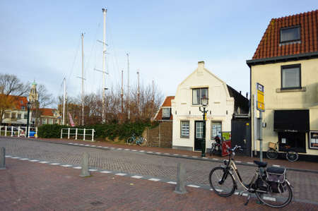Enkhuizen, North Holland / Netherlands - March 05, 2012: Houses and bicycle on the road on a street of Enkhuizen city of Netherlands at sunny spring day.のeditorial素材