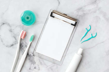 Set of pink and turquoise blue toothbrushes, toothpaste and other tools on marble background. Dental and health care concept. Top view, flat lay. Free copy space.の写真素材