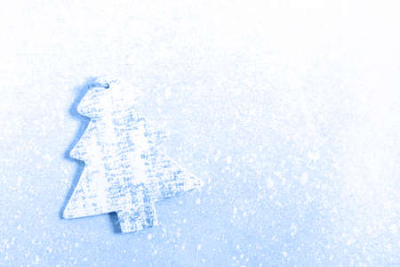 Christmas toy in shape of toy on white textured background. Christmas holiday celebration concept. Blue color toned image.の写真素材