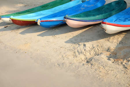 Kayaks stacked on sand beach. Colorful boats in front of sea coast. Vacation and travel sport activity. Free copy space.の写真素材