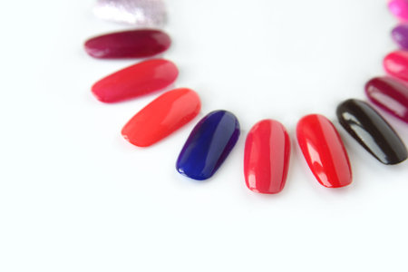 Nail polish samples in different bright colors. Colorful nail lacquer manicure swatches. Top view of...