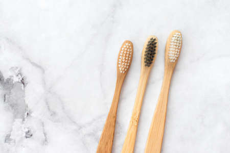 Two bamboo toothbrushes on marble background. Dental and healthcare concept. Top view, flat lay. Free copy space.の写真素材