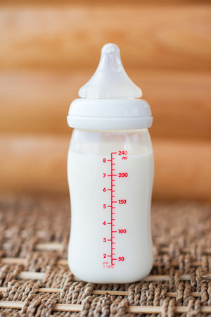 Bottle with breast milk for baby on wooden background. Maternity and baby care concept. Top view.の写真素材