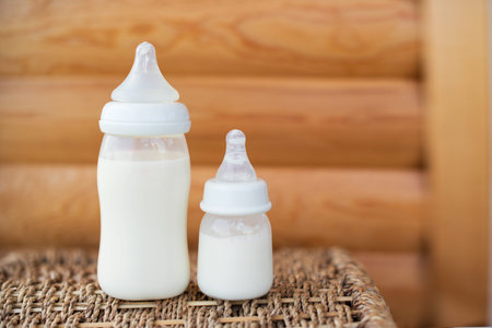 Bottles with breast milk for baby on wooden background. Maternity and baby care concept. Top view. Free copy space.の写真素材