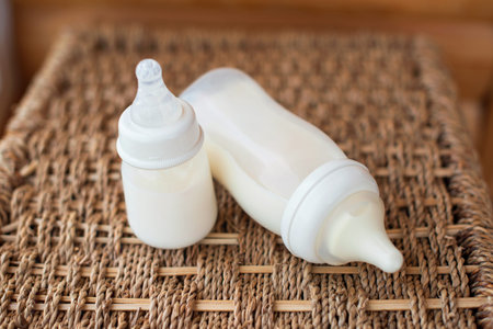 Bottles with breast milk for baby on straw basket background. Maternity and baby care concept. Top view.の写真素材