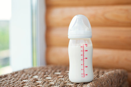 Bottle with breast milk for baby on wooden background. Maternity and baby care concept. Top view. Free copy space.の写真素材