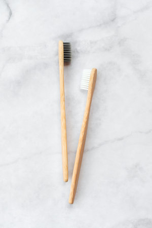Two bamboo toothbrushes on marble background. Dental and healthcare concept. Top view, flat lay.の写真素材