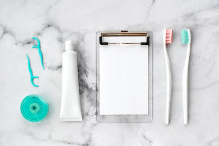 Set of pink and turquoise blue toothbrushes, toothpaste and other tools on marble background. Dental and health care concept. Top view, flat lay. Free copy space.の写真素材
