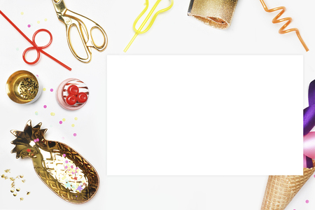 Party invitation mock-up. Flat lay, Cake with strawberries, colored tape. White background with party accessories.golden item. White blank on the tableの写真素材