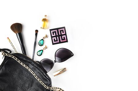 Woman bag on the white table, makeup accessories and jewerly with perfume. Female white mock-up background. Flat layの写真素材