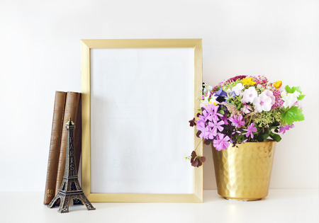 Gold frame mock-up, and white wall with gold vase, and flowers. Place workの写真素材