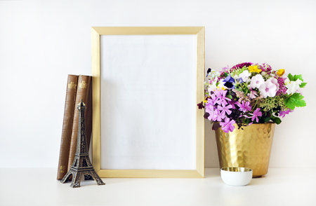 Gold frame mock-up, and white wall with gold vase, and flowers. Place workの写真素材