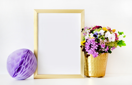 Gold frame mock-up, and white wall with gold vase, and flowers. Place workの写真素材