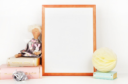 wooden picture frame with decorations. Mock up for your photo or text Place your work, print art,shabby style, white background, paper ball, toy, pastel color bookの写真素材