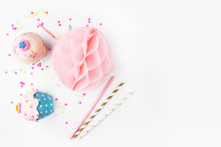 White background with party accessories. Invitation mockup. Confetti and muffins. cake. Flat lay.の写真素材