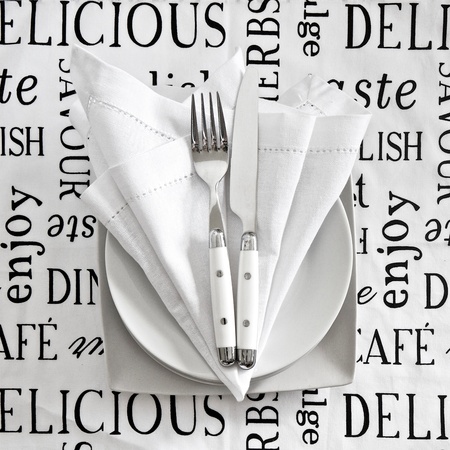 Table setting with cutlery and crockery on printed linen tableclothの写真素材