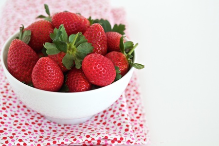 Strawberries in a white bowl with space for textの写真素材