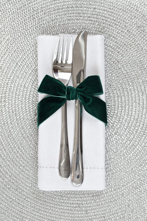 Knife and fork wrapped in green velvet ribbon for Christmasの写真素材