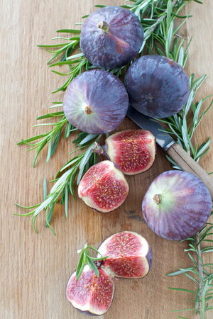 Fresh Figs and Rosemary on a wooden boardの写真素材