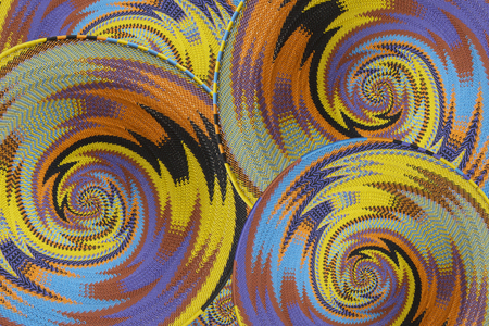 Woven baskets as a background made with vibrant coloured plastic coated telephone wire by African craftsmenの写真素材