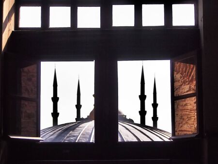 Mosque minarets through a windowの写真素材